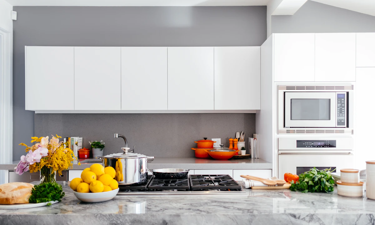 A spotless white kitchen with a marble island